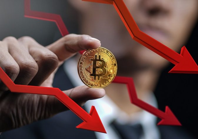 Bitcoin Price Falling Down. Businessman Holding Bitcoin With Red 3D Arrow Down